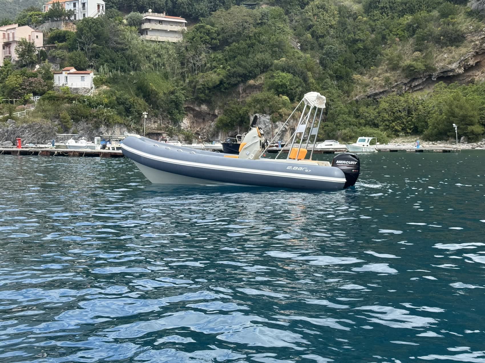 2BAR 57 ormeggiata in baia con montagne sullo sfondo