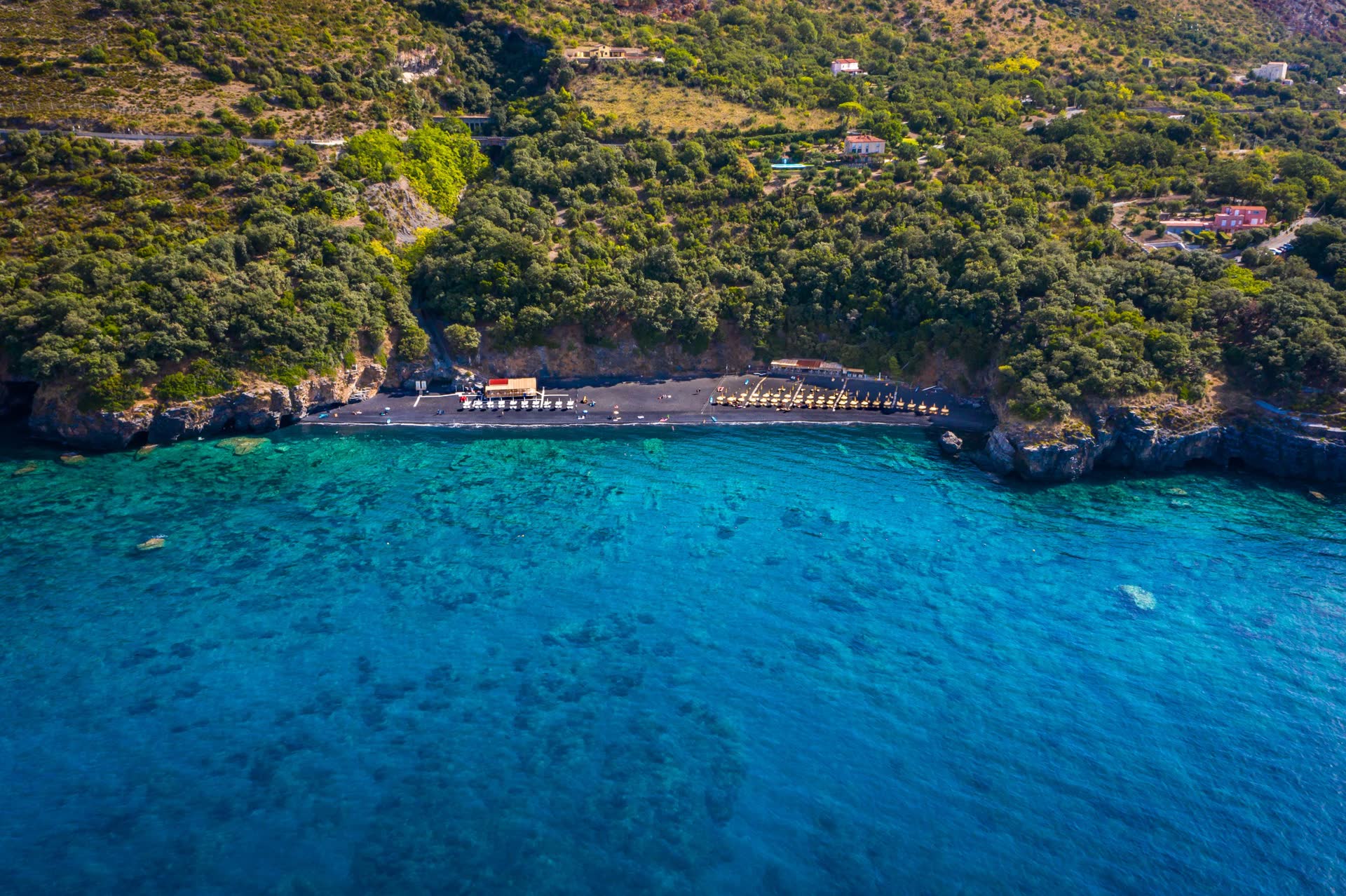 Spiaggia di sabbia nera che scende ripida nell'acqua