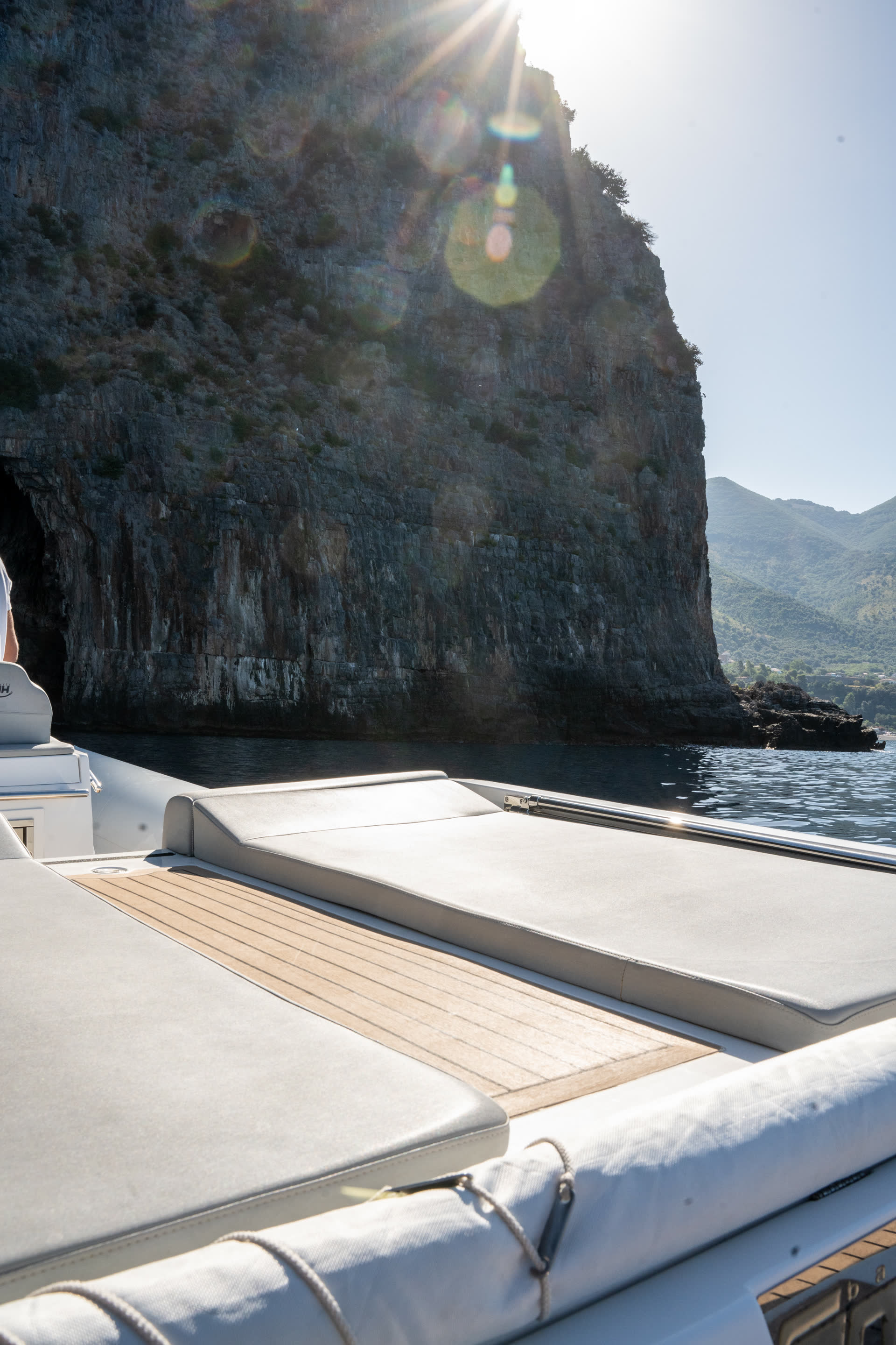 Prua di NOAH 29 con scogliera del Golfo e sole sopra